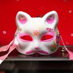 Masque japonais chat blanc en résine avec motifs floraux roses et dorés, rubans roses et clochette