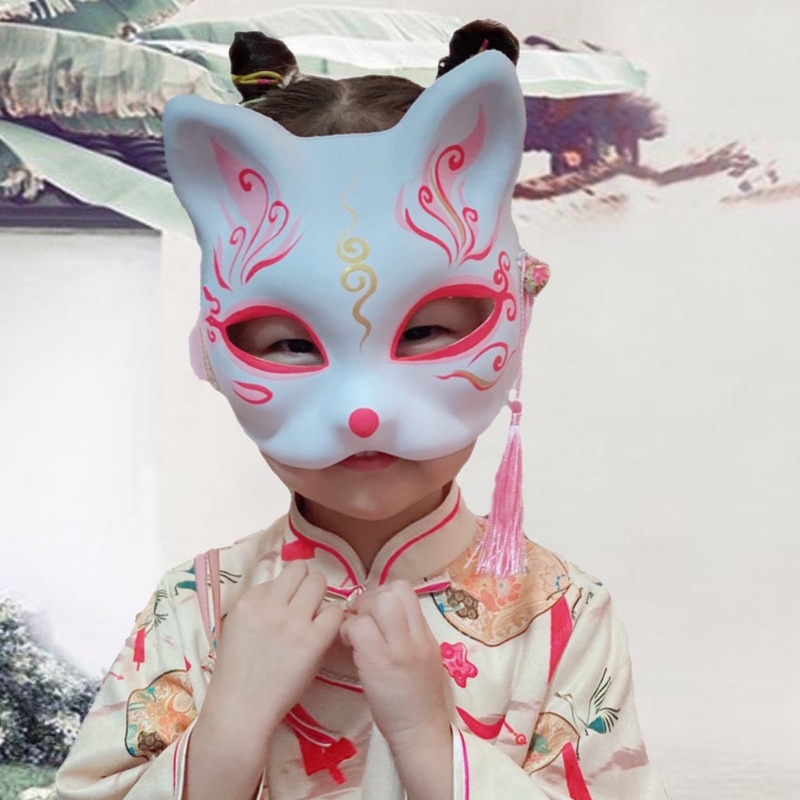 Masque japonais chat porte-bonheur blanc avec motifs rouges et dorés porté par un enfant en costume traditionnel