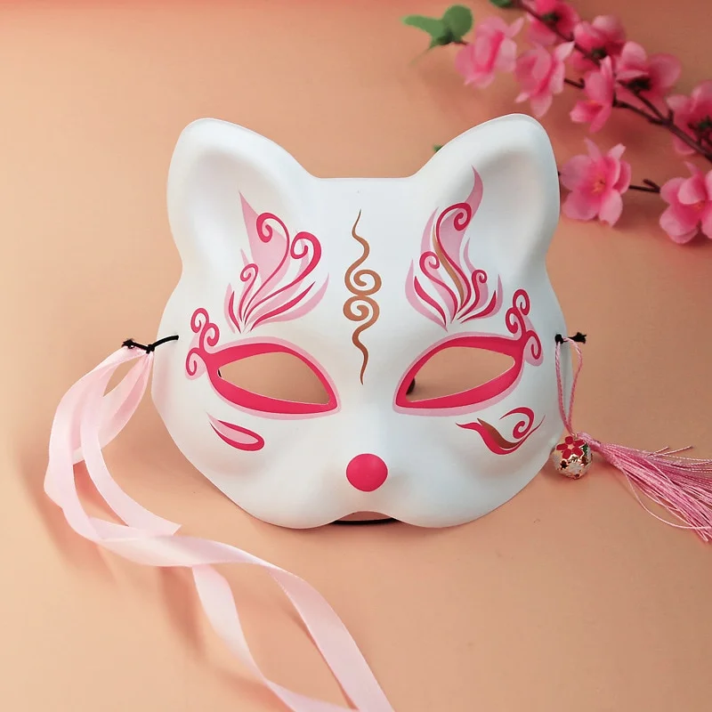 Masque japonais en forme de chat porte-bonheur blanc avec motifs rouges et dorés, rubans roses et clochette décorative
