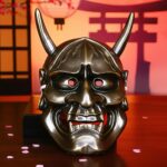 Masque japonais Hannya métallisé couleur bronze avec cornes, visage démoniaque traditionnel du folklore japonais