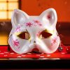 Masque japonais Kitsune blanc avec fleurs roses et dorées, décor floral détaillé, masque rituel en forme de renard sacré