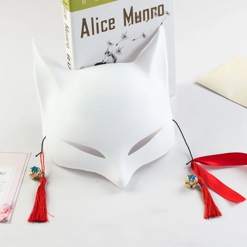 Masque japonais Kitsune blanc en forme de renard avec pompons rouges et petites cloches, vue de face