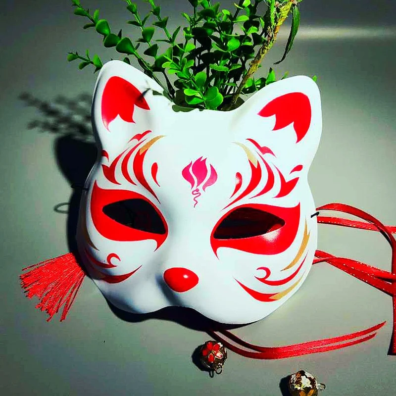 Masque japonais Kitsune Le Stratège blanc en résine avec motifs rouges traditionnels et rubans rouges, vue de face