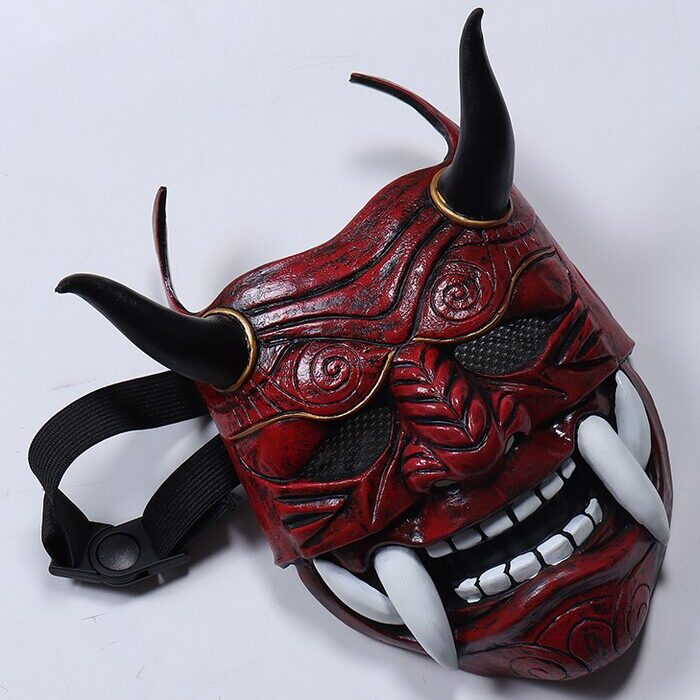 Masque japonais Oni rouge en matériau rigide avec cornes noires, détails sculptés et dents blanches proéminentes, vue de face avec sangle noire